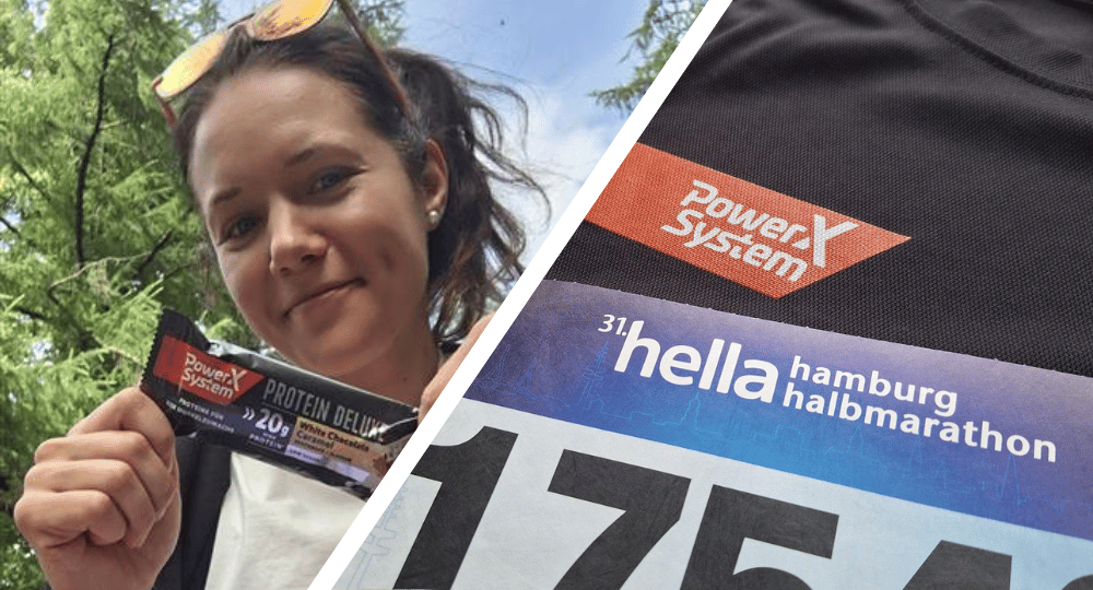 Eine Teilnehmerin hält den Power System Riegel in die Kamera und lächelt, daneben sehen wir ein Power System Laufshirt und die Startnummer für den hella Halbmarathon 2025