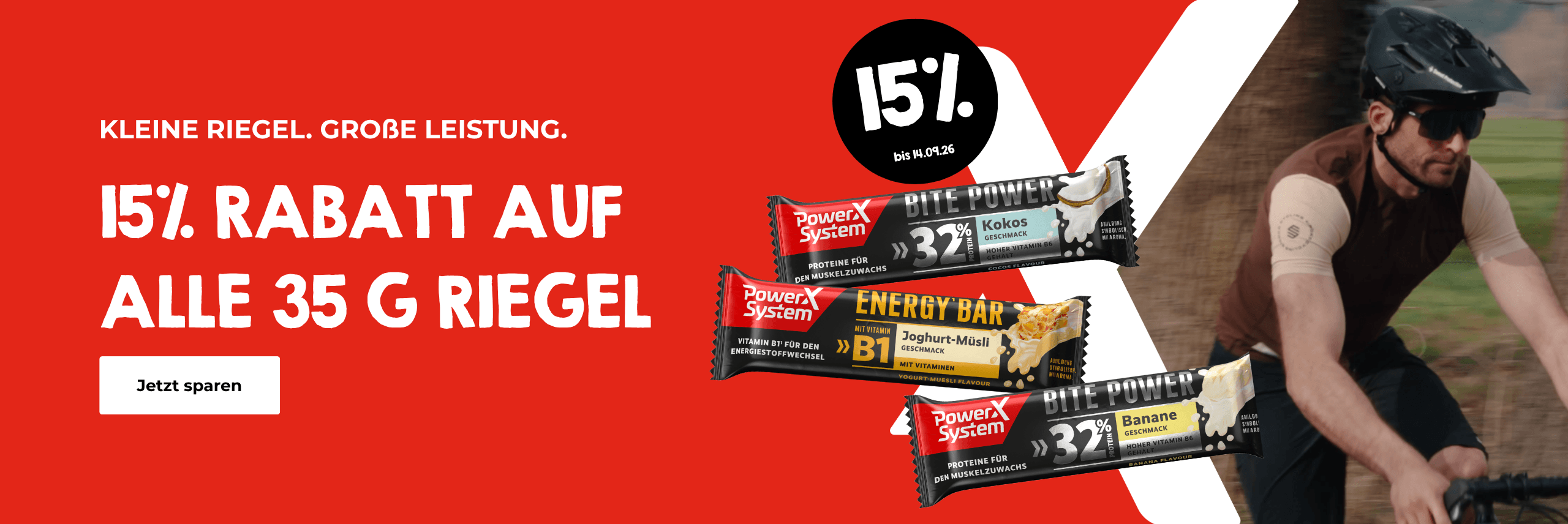 Werbebanner mit rotem Hintergrund: 15% Rabatt auf alle 35g Riegel von PowerX System bis 14.09.26. Drei Produkte abgebildet: Bite Power Kokos (32% Protein), Energy Bar Joghurt-Müsli (mit Vitamin B1) und Bite Power Banane (32% Protein). Rechts ein Radfahrer mit Helm und Sonnenbrille auf dem Fahrrad. Slogan: Kleine Riegel. Große Leistung. Button: Jetzt sparen.