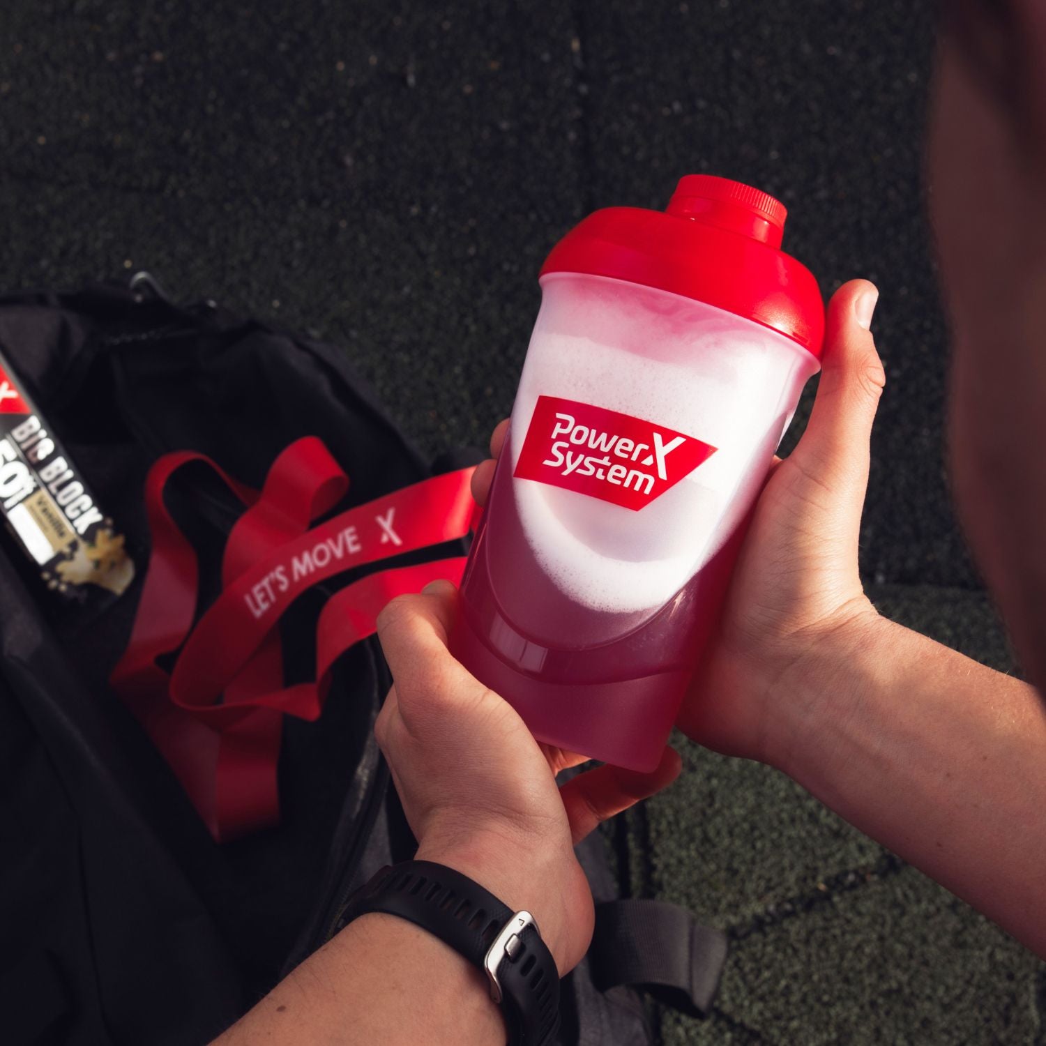 Mann nimmt Shaker mit Protein Limo aus einer Sporttasche